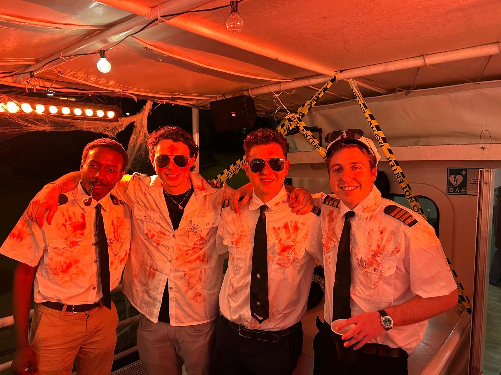 Les quatre organisateurs en chemise de capitaine tachée de faux sang, à bord de la péniche décorée pour Halloween.