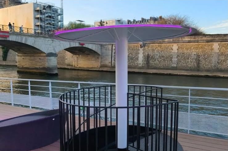 Un mange-debout éclairé en violet sur le pont, face à la Seine.